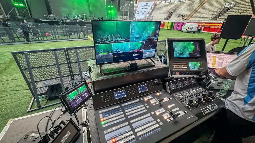 Control de realización multicámara con panel ATEM y multiviewer frente al escenario de un concierto