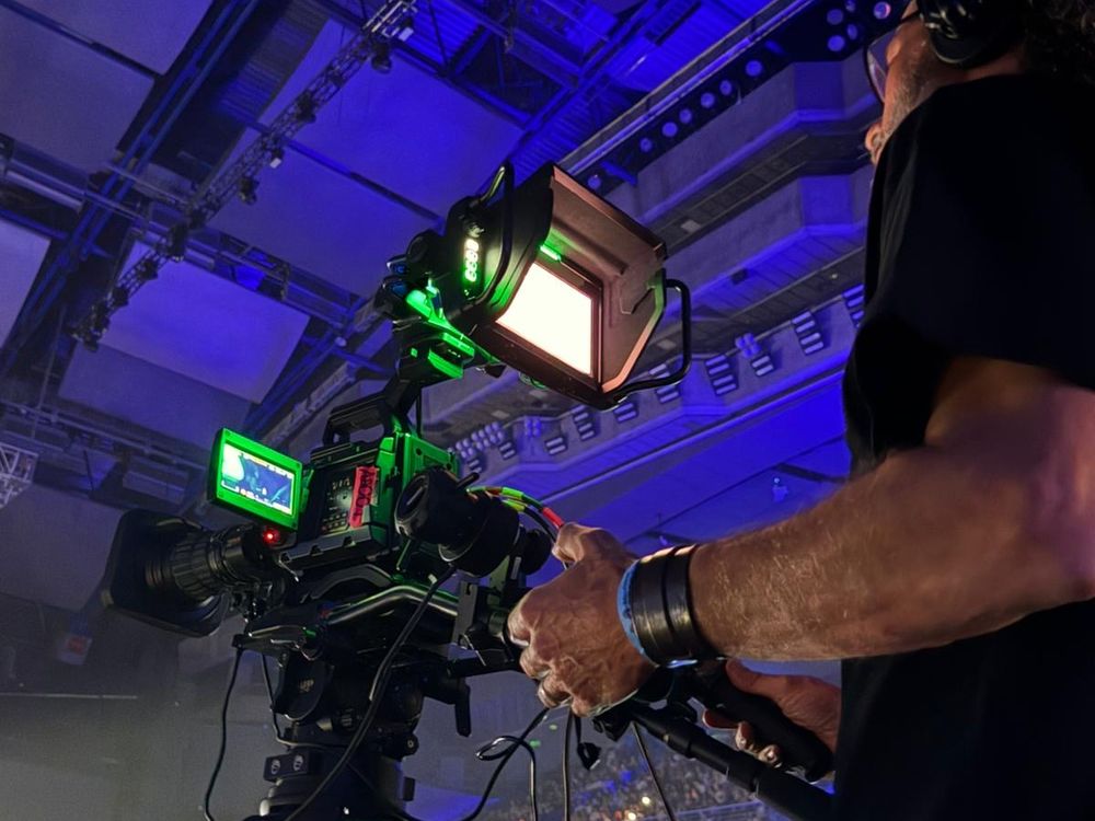 Operador de cámara broadcast siguiendo un concierto en directo con intercom y monitor de campo