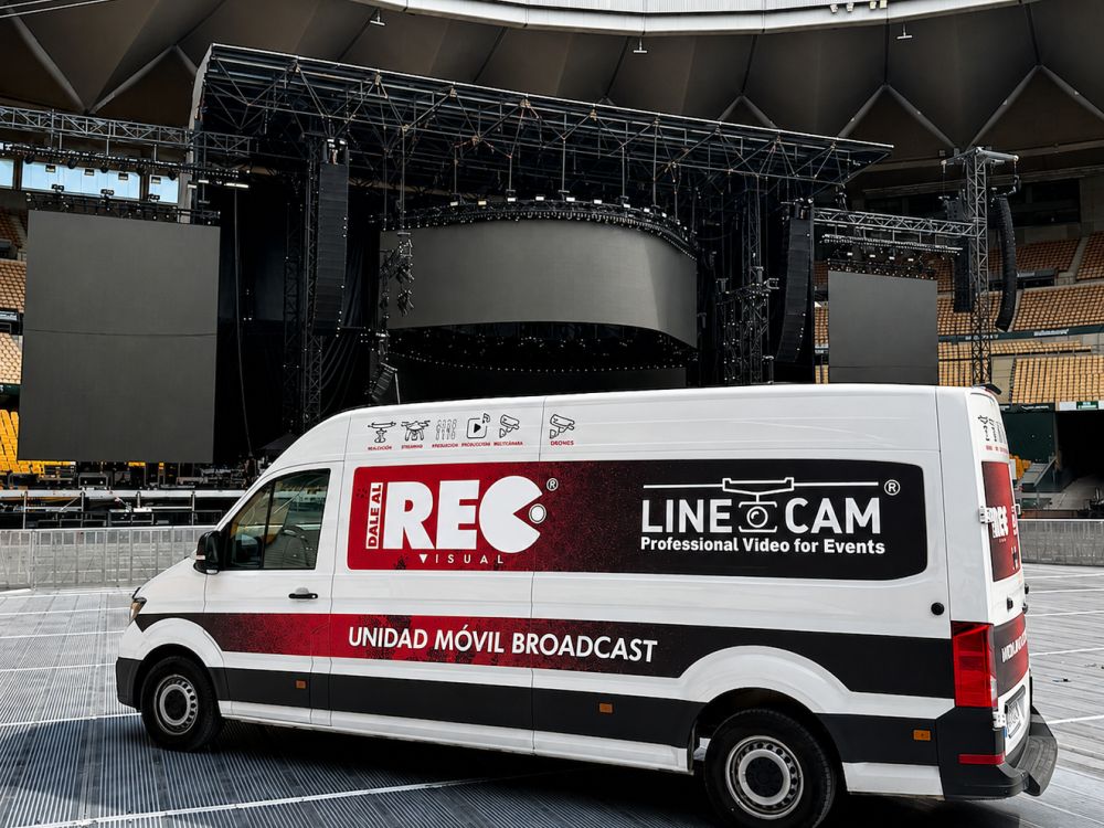 Unidad móvil broadcast situada frente al escenario de un concierto en un estadio